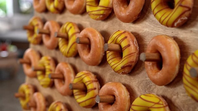 Side view on donuts hung on a peg board as a dessert display, with dramatic light.