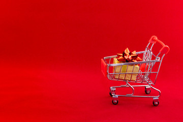 shopping cart with gifts on red background