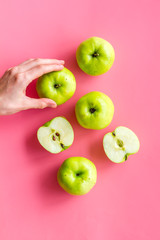 Autumn composition with green apple on pink background top view