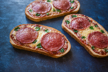 hot open sandwiches with salami cheese tomato sauce pepperoni pizza style   close up