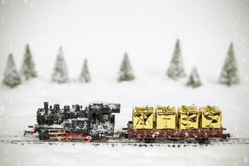 Goldene Geschenke auf einem Modellbauzug in einer Winterlandschaft