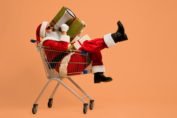 Santa shouting in megaphone while sitting in shopping cart