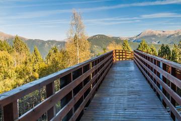 Fototapeta na wymiar Wooden foot bridge over the road to Ski resort La Serra, Andorra