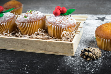 Christmas cupcakes decorated with mistletoe in a wooden box. Sweet gift. Christmas sweet food. Mini muffins.