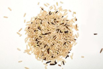 handful of brown rice on a white table