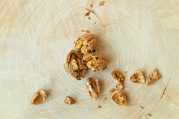 Walnut crushed shells and kernels on wooden birch tree cutting board closeup top view with copy space 