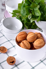 Walnut shaped cookies with condensed milk in a round box against white background