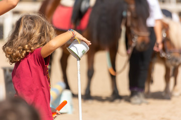 Child that takes a Cup during Pony Games - obrazy, fototapety, plakaty