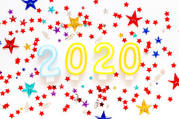 2020 New Year card. Candles and confetti on white background top view