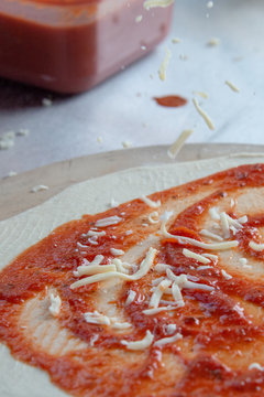 mozzarell cheese being dropped on to pizza base