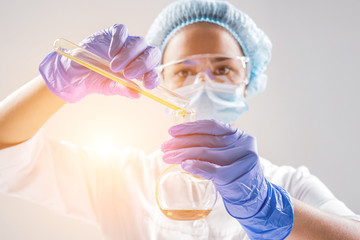 Scientist pouring organic oil. Beauty and cosmetics sciences. Laboratory equipment