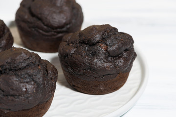delicious chocolate muffins on a plate, top view
