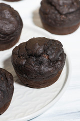 delicious chocolate muffins on a plate, vertical top view