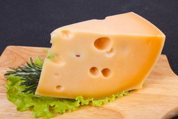 Maasdam cheese  in the board served salad leaves