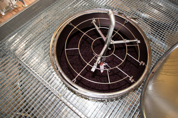 Modern winery machine with red grapes steel cellar grape fermenting