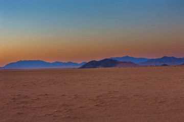 Fototapeta na wymiar Blue mountains after sunset in the desert