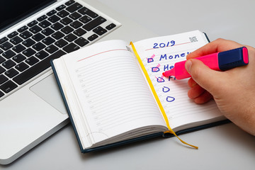Man's arm marks task completed in daily organizer