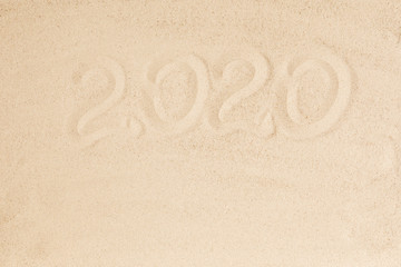 Happy New Year 2020, lettering on golden sand beach. Flat lay, top view, copy space