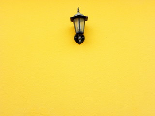 Old street lamp on a yellow wall