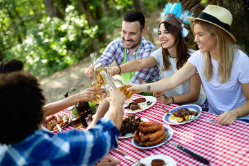 Group of happy friends having outdoor barbecue party and fun together