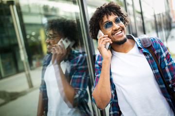 Handsome hipster man with beard in town calling on mobile phone