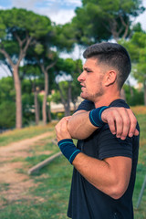 Fototapeta premium Strong athlete Brutal athletic, man warmed up in the park outdoor gym training. Gymnastic bar during training.