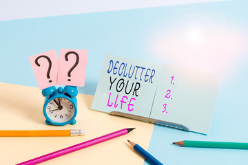 Writing note showing Declutter Your Life. Business concept for To eliminate extraneous things or information in life Mini size alarm clock beside stationary on pastel backdrop