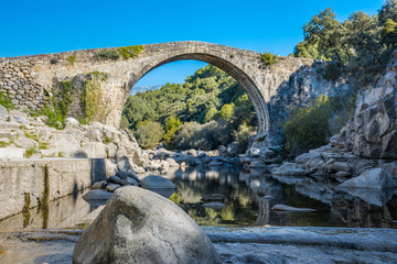 Stone bridge over the rocky gorge of the Alardos river. Madrigal de la Vera, Caceres, Extremadura, Spain.