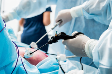 Process of gynecological surgery operation using laparoscopic equipment. Group of surgeons in...