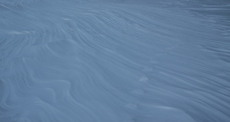 Snow-white snow and the earth sheltered by it. Countryside and snowfall. Winter dunes and mountains of snowflakes. Stock background.