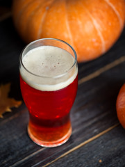 A glass of traditional pumpkin beer ale on a wooden table