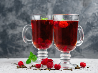 Red tea with raspberries in glass