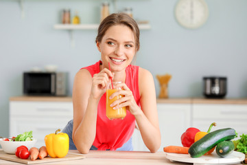 Young woman drinking healthy juice in kitchen. Diet concept