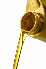 Filling engine oil from a golden canister. Canister with a splash of engine oil isolated on a white background close-up.