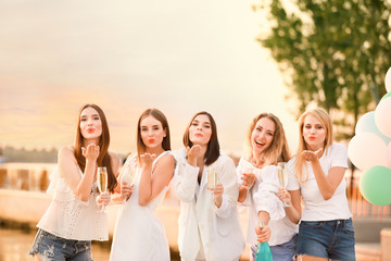 Beautiful young women drinking champagne at hen party outdoors