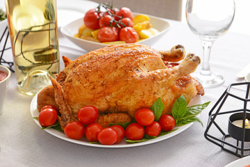 Plate with tasty baked chicken and tomato on served table