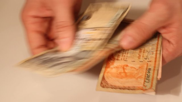 Man's hands counting Nepalese Rupee banknotes. National Currency of Nepal (NPR)