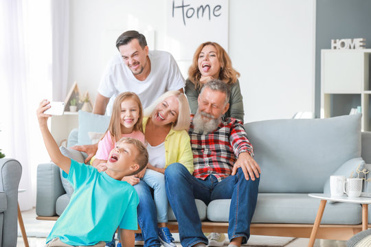 Little boy taking photo with his family at home