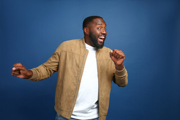 Happy African-American man on color background