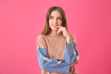 Thoughtful young woman on color background