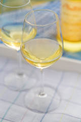 Sunset view of two wine glasses and bottle of white wine on the background of Kotor bay, Montenegro.