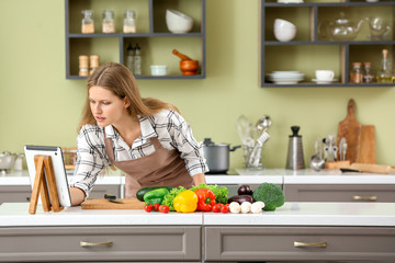 Beautiful young woman cooking in kitchen