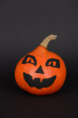 The orange pumpkin painted for Halloween on black background