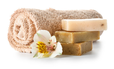 Towel, soap and flower on white background