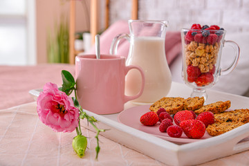 Tray with tasty breakfast on table in bedroom, closeup