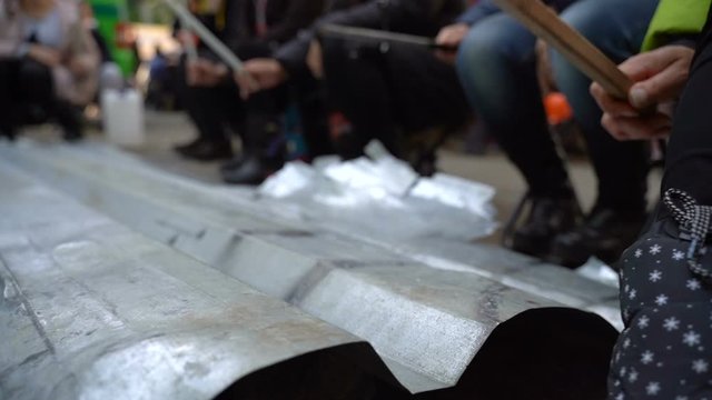 Protesters hit metal sheets with batons on protest rallies. Slow motion. Video with sound
