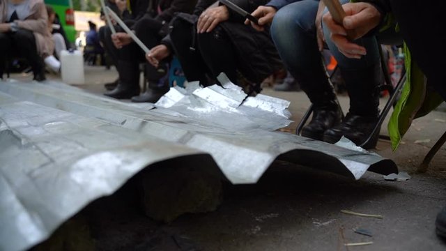 Protesters hit metal sheets with batons on protest rallies. Slow motion. Video with sound