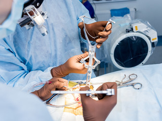 Spinal surgery. Group of surgeons in operating room with surgery equipment. Laminectomy