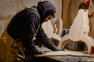 Carpenter polishing wood in workshop
