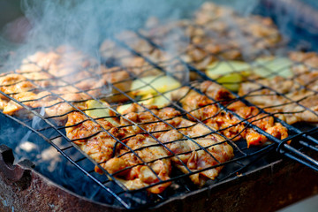 Chicken shashlik being roasted over charcoal on grill